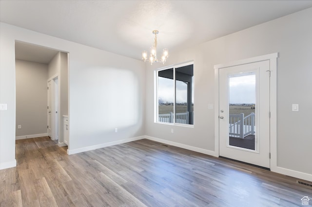 2833 W 3050 N Unit 11, Plain City, UT 84404 - unfurnished dining area featuring baseboards, wood finished floors, visible vents, and a notable chandelier