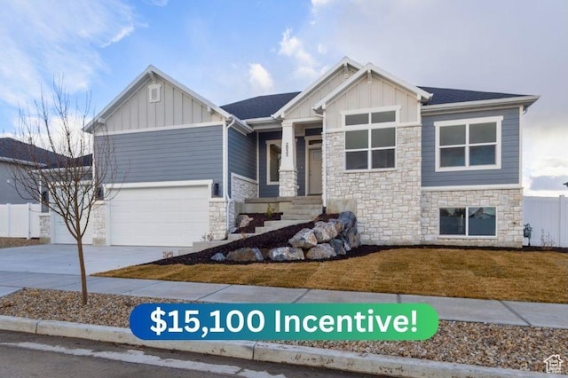view of front of property with concrete driveway, a front lawn, stone siding, board and batten siding, and a garage