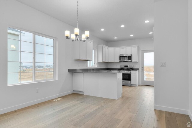 6737 N Tulle Mtn, Eagle Mountain, UT 84005 - kitchen featuring a peninsula, baseboards, a notable chandelier, and appliances with stainless steel finishes