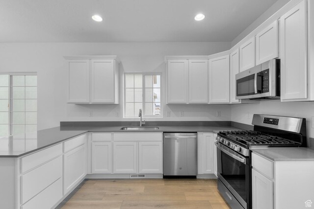 6737 N Tulle Mtn, Eagle Mountain, UT 84005 - kitchen with a peninsula, white cabinetry, stainless steel appliances, and a sink