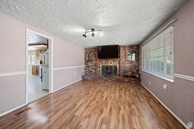 336 W 200 N, Bountiful, UT 84010 - unfurnished living room featuring a textured ceiling, visible vents, wood finished floors, and a fireplace