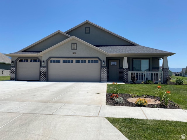 332 N 3250 W Unit 3, West Point, UT 84015 - view of front facade with a garage, driveway, covered porch, a front yard, and stucco siding