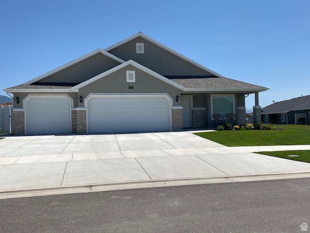 332 N 3250 W Unit 3, West Point, UT 84015 - view of front of house with a front lawn, driveway, brick siding, an attached garage, and stucco siding