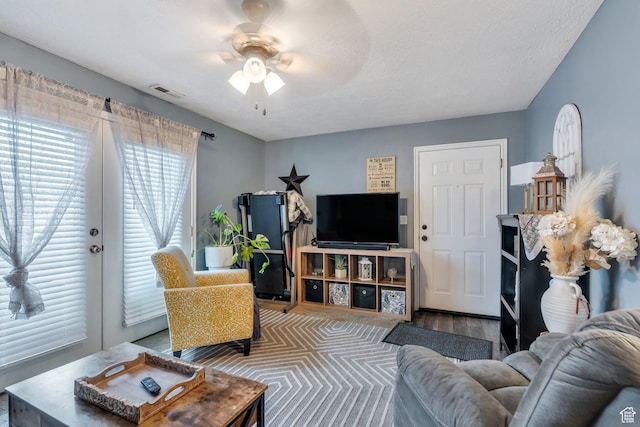 living area featuring visible vents, wood finished floors, and ceiling fan