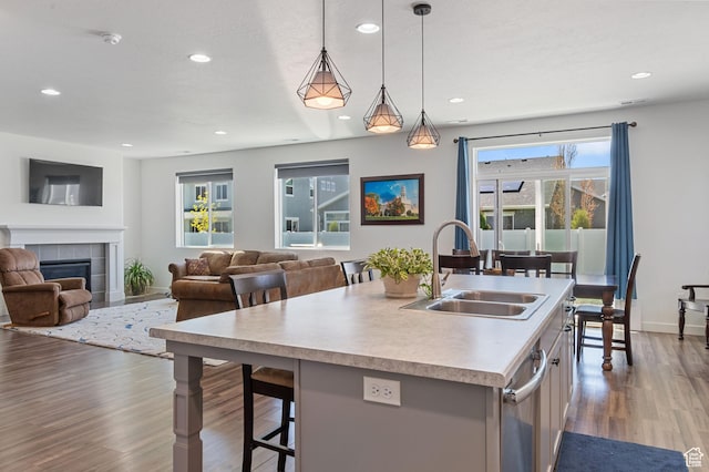 kitchen with a healthy amount of sunlight, wood finished floors, a sink, and light countertops