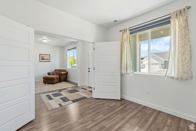 interior space featuring baseboards, wood finished floors, and visible vents