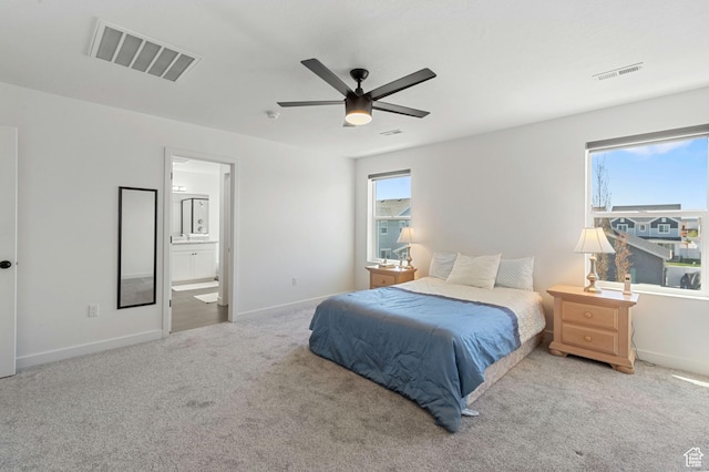 carpeted bedroom featuring connected bathroom, baseboards, a ceiling fan, and visible vents
