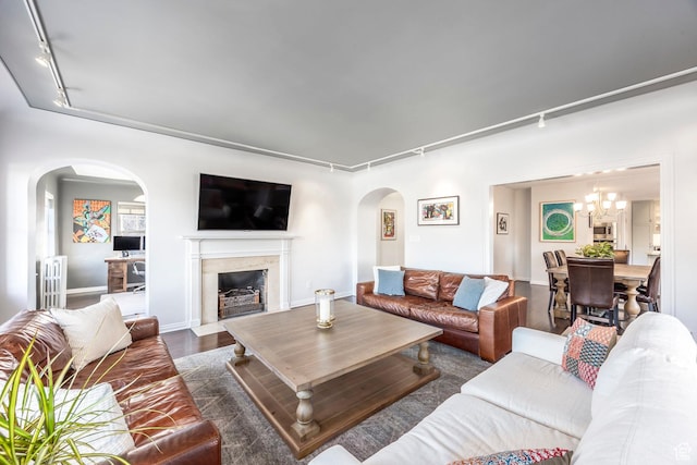 1283 E S Temple Unit 503, Salt Lake City, UT 84102 - living area featuring rail lighting, arched walkways, radiator heating unit, dark wood-style floors, and a chandelier