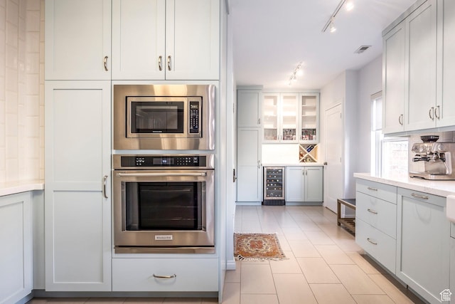 1283 E S Temple Unit 503, Salt Lake City, UT 84102 - kitchen with appliances with stainless steel finishes, track lighting, wine cooler, light countertops, and light tile patterned flooring