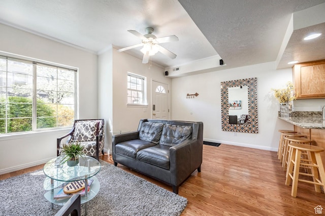 2503 S 160 E Unit 6D, Ogden, UT 84401 - living room featuring a ceiling fan, baseboards, light wood-style floors, and crown molding