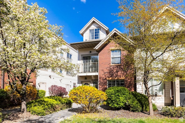 view of front of property with brick siding and a balcony