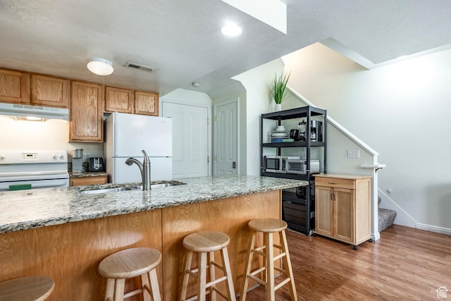 2503 S 160 E Unit 6D, Ogden, UT 84401 - kitchen with a kitchen breakfast bar, under cabinet range hood, visible vents, a sink, and white appliances