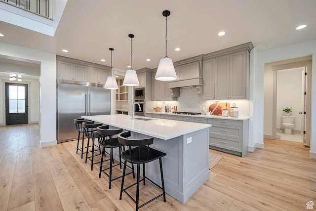 819 W Sara Dr, Saratoga Springs, UT 84045 - kitchen featuring built in appliances, an island with sink, a breakfast bar area, and gray cabinets