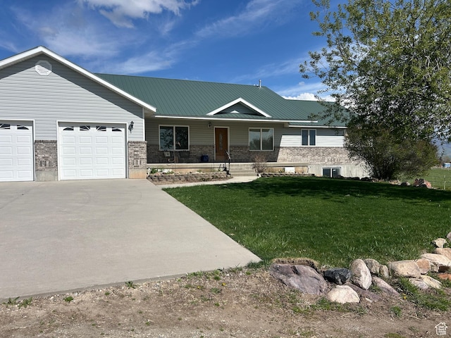 view of front of house with a porch, metal roof, driveway, a front lawn, and an attached garage