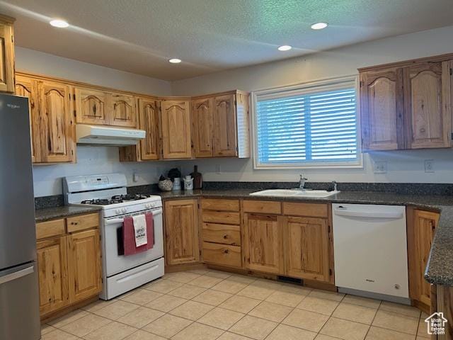 1176 E 900 S, Preston, ID 83263 - kitchen with brown cabinets, a sink, under cabinet range hood, recessed lighting, and white appliances