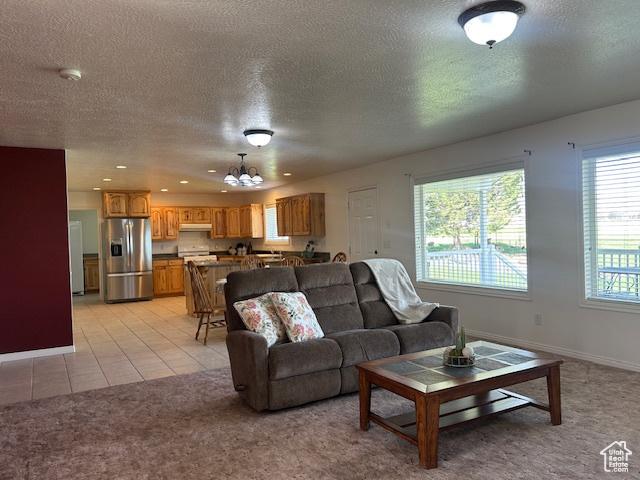 1176 E 900 S, Preston, ID 83263 - living room featuring light colored carpet, baseboards, a notable chandelier, and a textured ceiling