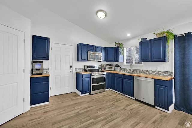 221 E Brookmeadow Dr, Harrisville, UT 84404 - kitchen with stainless steel appliances, wooden counters, blue cabinetry, vaulted ceiling, and a sink