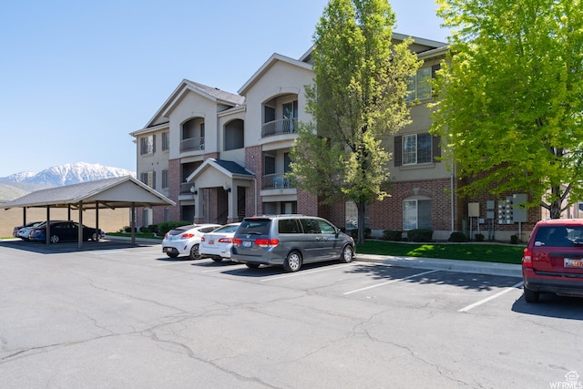 view of building exterior featuring uncovered parking and a mountain view