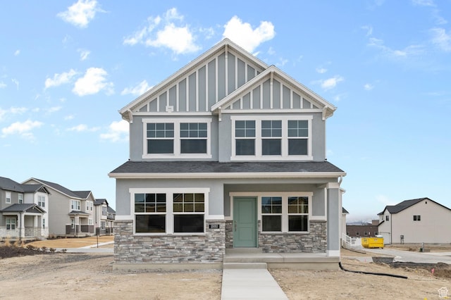 craftsman house featuring stucco siding, stone siding, a residential view, and board and batten siding