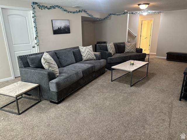 carpeted living area featuring baseboards, stairs, and visible vents