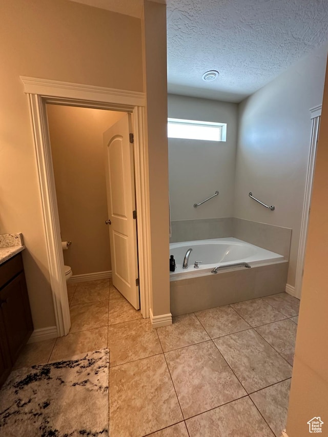 full bath with a bath, a textured ceiling, toilet, tile patterned flooring, and vanity