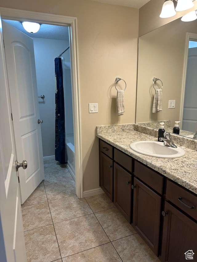 full bathroom with baseboards, tile patterned floors, vanity, and shower / bathtub combination with curtain