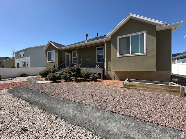 ranch-style home with stucco siding and fence