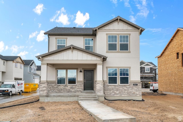 craftsman inspired home featuring board and batten siding, covered porch, and stucco siding