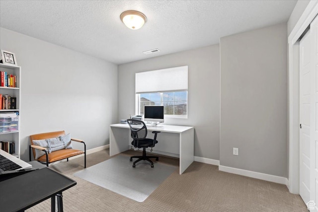 carpeted office with baseboards, a textured ceiling, and visible vents