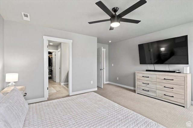 bedroom with a ceiling fan, a spacious closet, carpet floors, baseboards, and visible vents