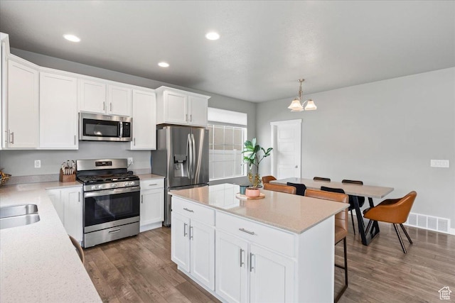 kitchen featuring dark wood finished floors, white cabinets, and appliances with stainless steel finishes