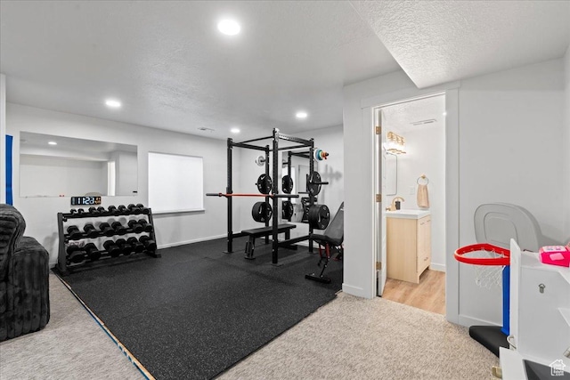 workout room with carpet, baseboards, a textured ceiling, and recessed lighting