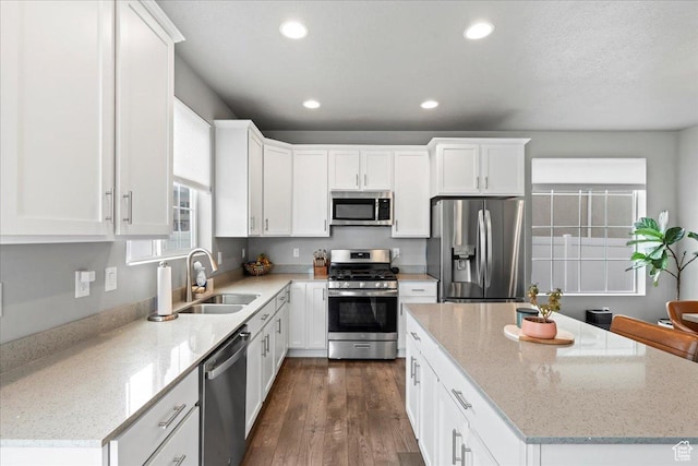 kitchen with appliances with stainless steel finishes, a sink, a kitchen island, and recessed lighting