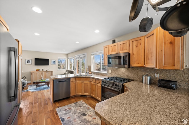 1975 Picabo St, Park City, UT 84098 - kitchen with wood finished floors, decorative backsplash, a peninsula, appliances with stainless steel finishes, and recessed lighting