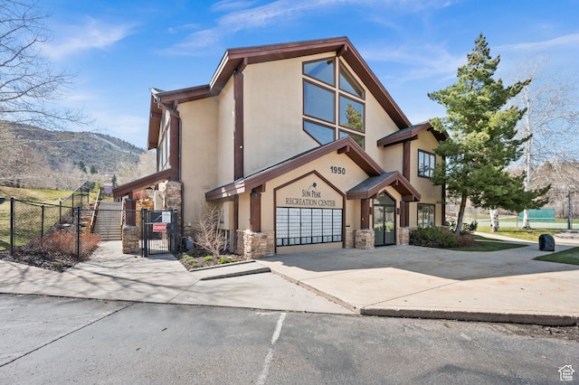 1975 Picabo St, Park City, UT 84098 - view of front of home with a gate, driveway, stone siding, fence, and stucco siding