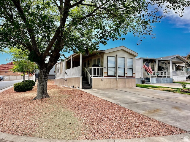 1150 W Red Hills Pkwy Unit 113, Washington, UT 84780 - manufactured / mobile home featuring concrete driveway and a sunroom