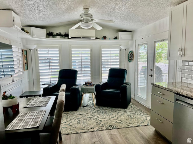 1150 W Red Hills Pkwy Unit 113, Washington, UT 84780 - living area with a textured ceiling, a wall unit AC, lofted ceiling, a ceiling fan, and wood finished floors