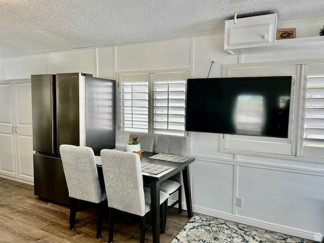 1150 W Red Hills Pkwy Unit 113, Washington, UT 84780 - dining room with wood finished floors, a textured ceiling, and a decorative wall