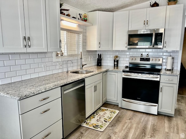 1150 W Red Hills Pkwy Unit 113, Washington, UT 84780 - kitchen featuring decorative backsplash, stainless steel appliances, a sink, and a textured ceiling