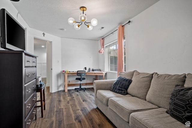 office featuring a notable chandelier, a textured ceiling, visible vents, and dark wood-style flooring