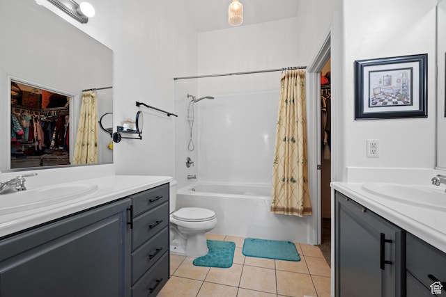 bathroom featuring tile patterned floors, toilet, vanity, a walk in closet, and shower / bath combo with shower curtain