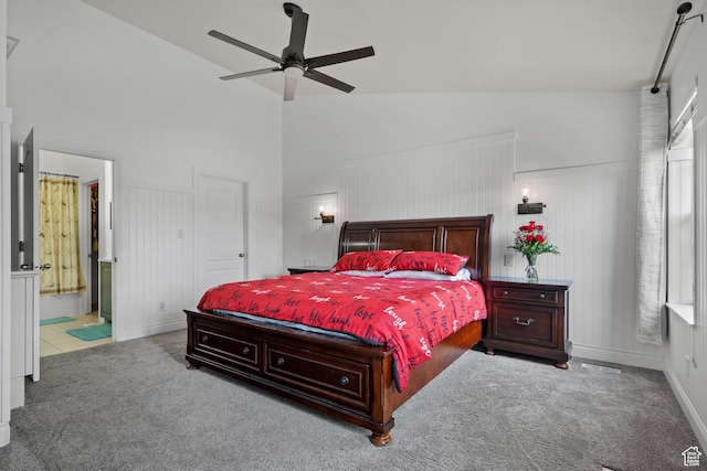carpeted bedroom with baseboards, ceiling fan, high vaulted ceiling, and ensuite bathroom