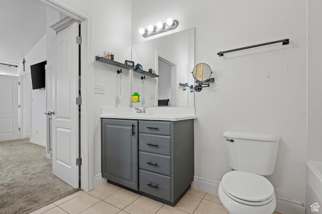 bathroom with baseboards, tile patterned flooring, vanity, and toilet