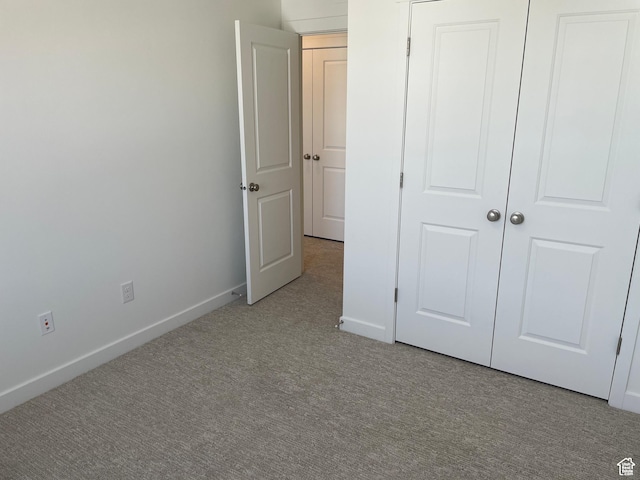 unfurnished bedroom featuring carpet floors and baseboards