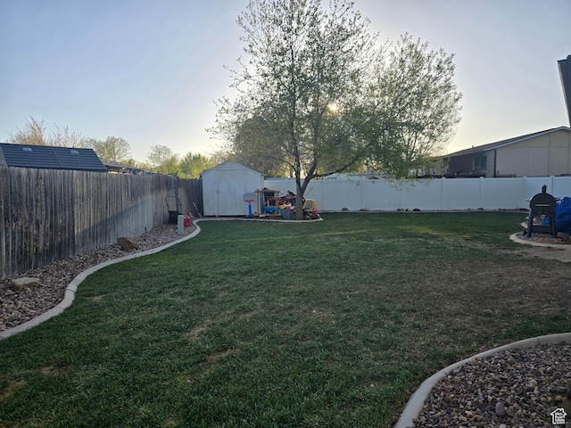 322 S 800 W, Vernal, UT 84078 - yard at dusk with a storage unit, an outbuilding, and a fenced backyard