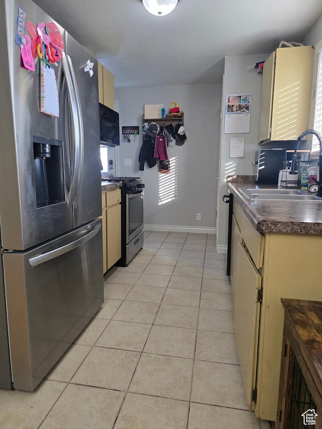 322 S 800 W, Vernal, UT 84078 - kitchen with dark countertops, a sink, light tile patterned flooring, appliances with stainless steel finishes, and cream cabinets