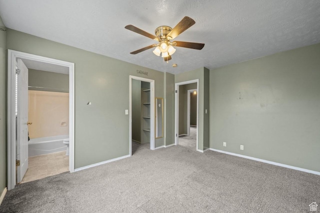unfurnished bedroom with a spacious closet, baseboards, and carpet floors