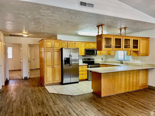 1050 W Red Hills Pkwy Unit 64, Washington, UT 84780 - kitchen featuring a peninsula, light wood-style flooring, visible vents, and stainless steel appliances