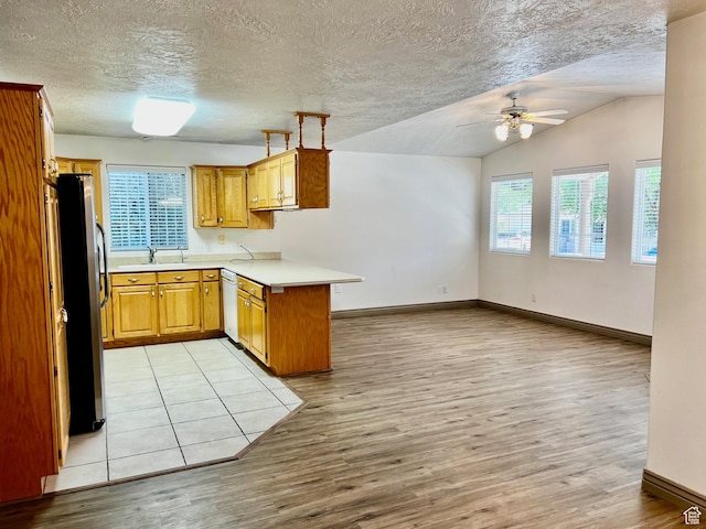 1050 W Red Hills Pkwy Unit 64, Washington, UT 84780 - kitchen featuring light wood finished floors, a peninsula, freestanding refrigerator, and ceiling fan