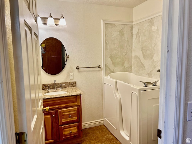 1050 W Red Hills Pkwy Unit 64, Washington, UT 84780 - bathroom with tile patterned flooring, vanity, baseboards, a garden tub, and washer / clothes dryer